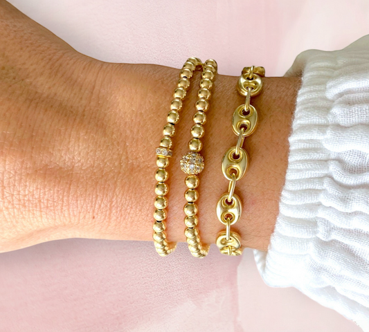 Model wearing the 18 Gold Plated Puffed Mariner Bracelet stacked with other gold bracelets