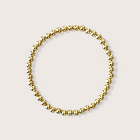 close up of a 4mm 14k gold filled beaded bracelet on white background