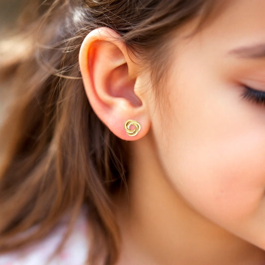 girl model wearing gold-filled knot design earrings