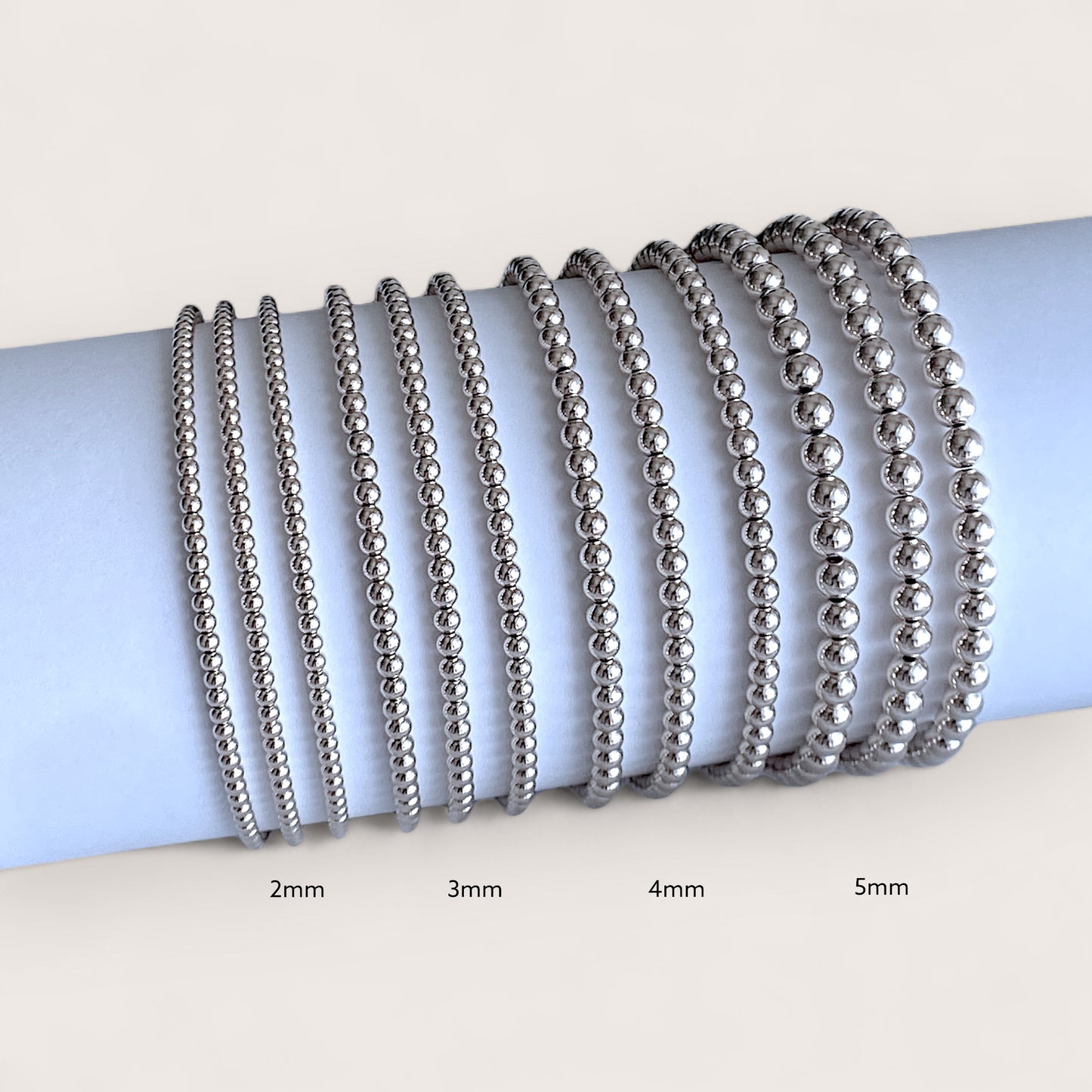 Close up image showing Sterling silver beaded bracelets, 2mm, 3mm 4mm, 5mm, side by side for comaprison