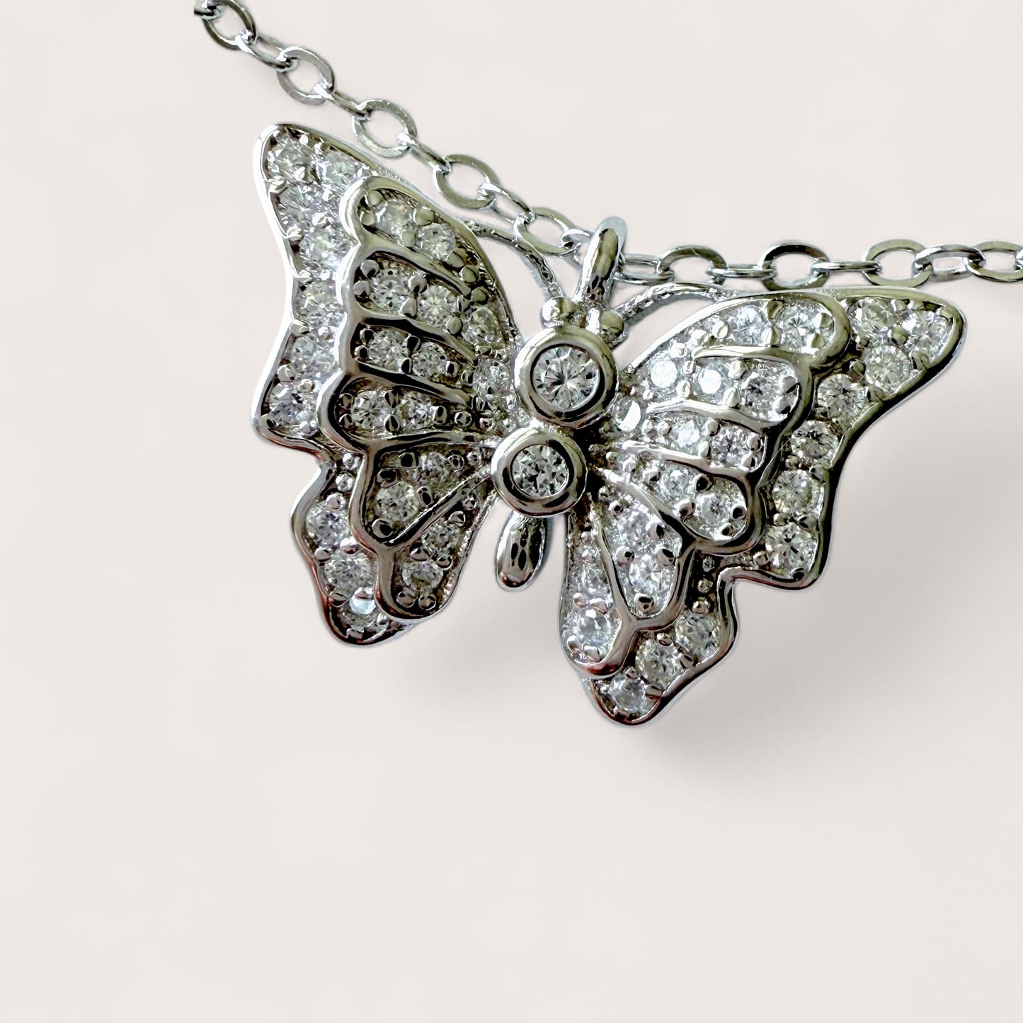 Butterfly-shaped necklace with diamond accents on a light background