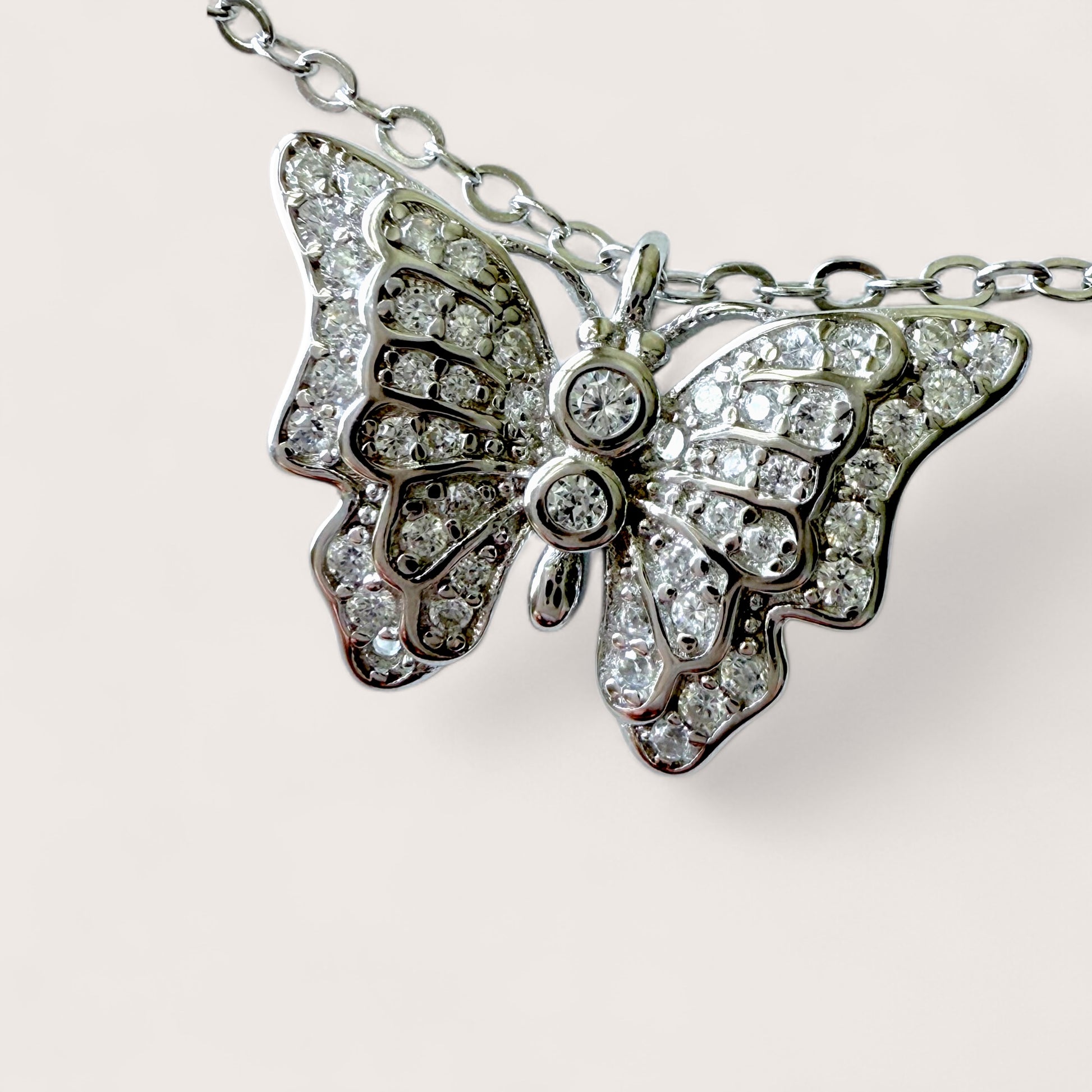 Butterfly-shaped necklace with diamond accents on a light background