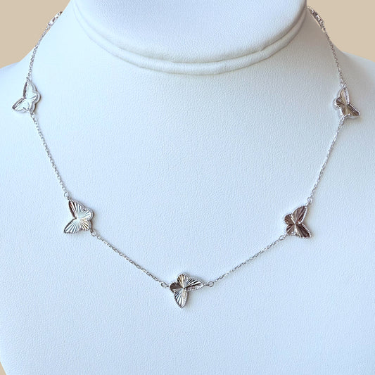 Close-up of faceted butterfly charm on high-polish silver chain