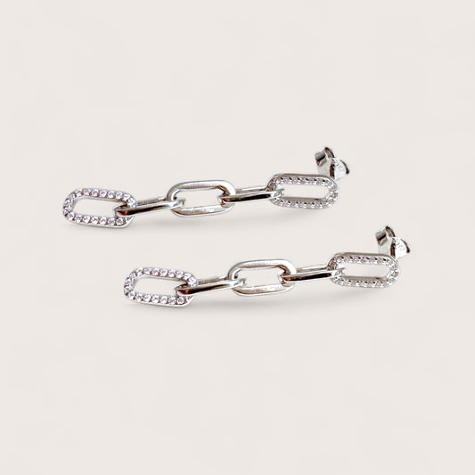 Pair of cz silver chain-link earrings on a light gray background