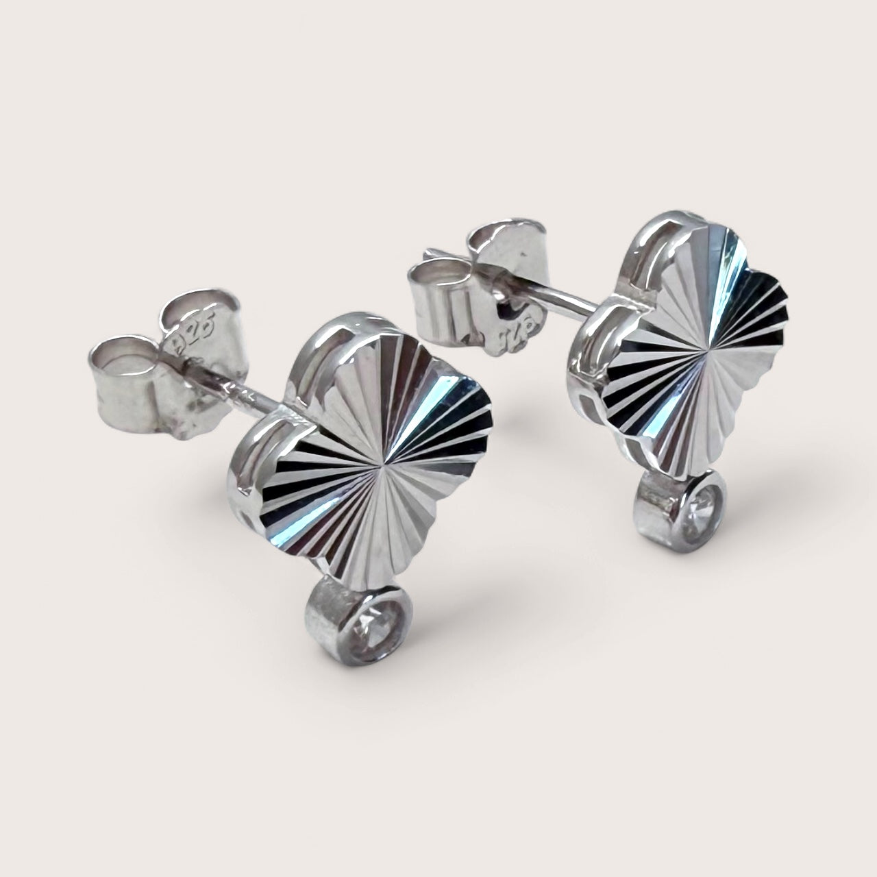 Side view of four leaf clover earrings with dangling clear cubic zirconia