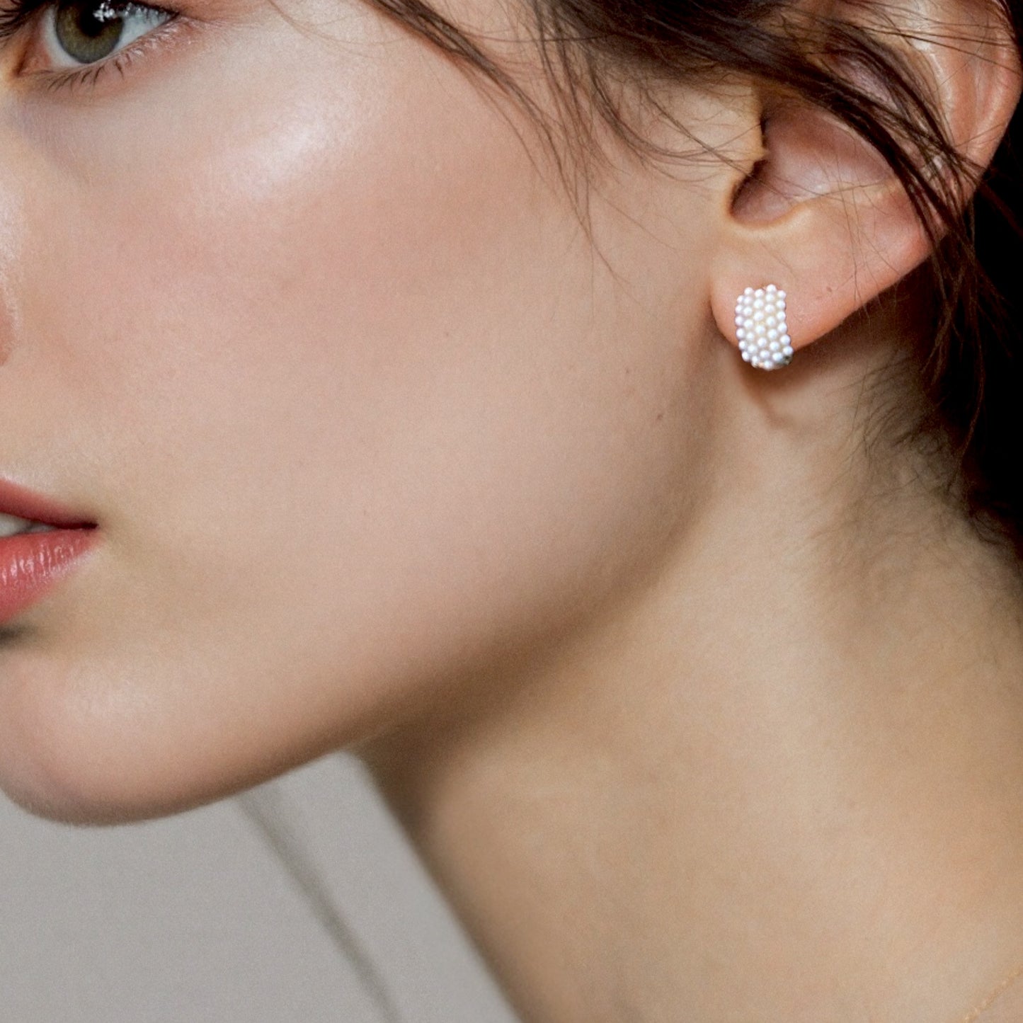 Pearl huggie earrings worn on ear – gold pavé pearl huggies by Ashley Nicole Jewelry