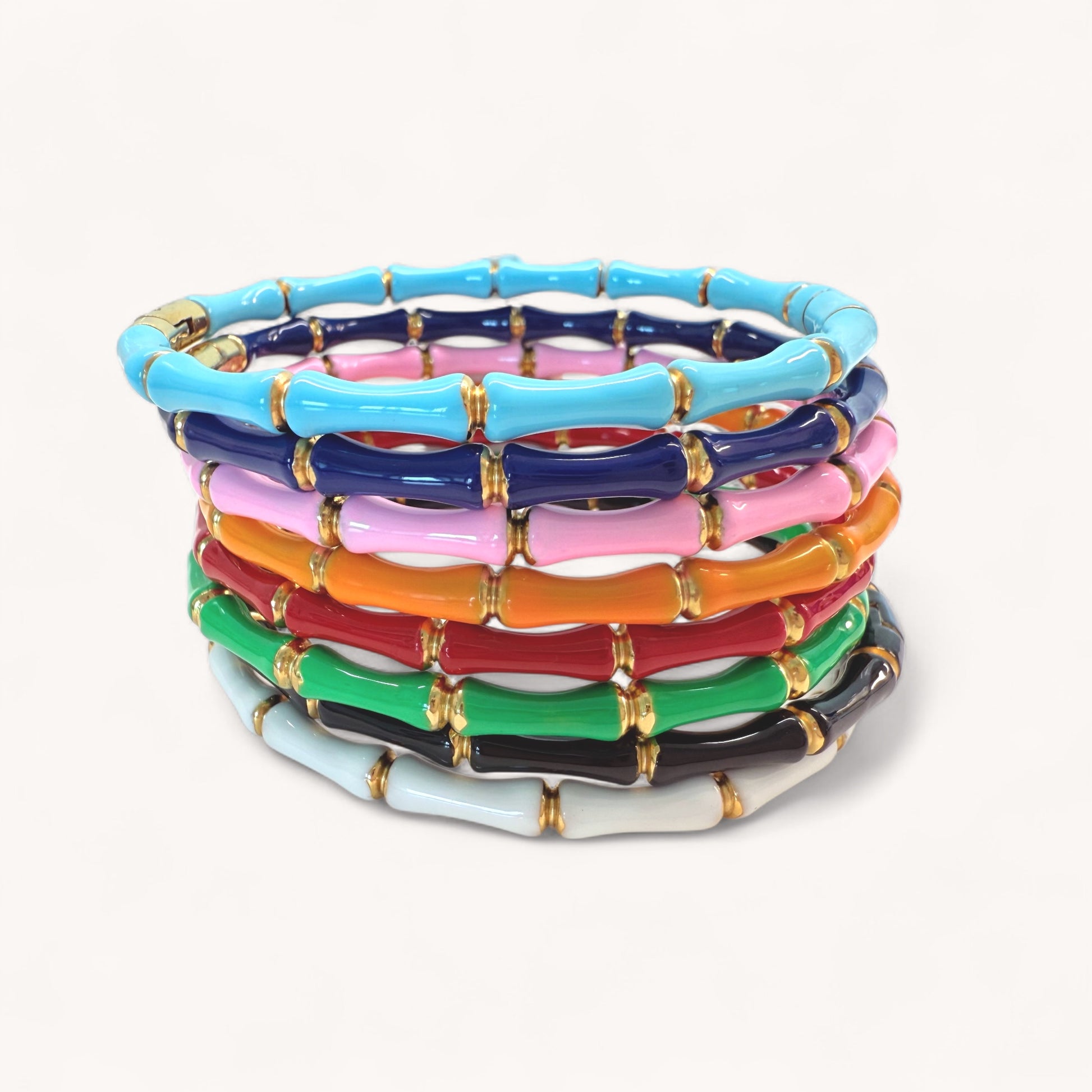 Stack of colorful bracelets with gold accents on a white background