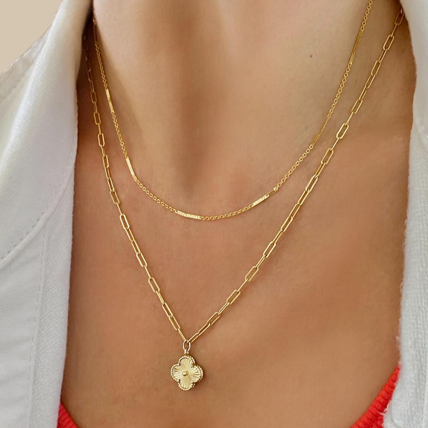 Model wearing gold station necklace layered with another pendant necklace for style inspo