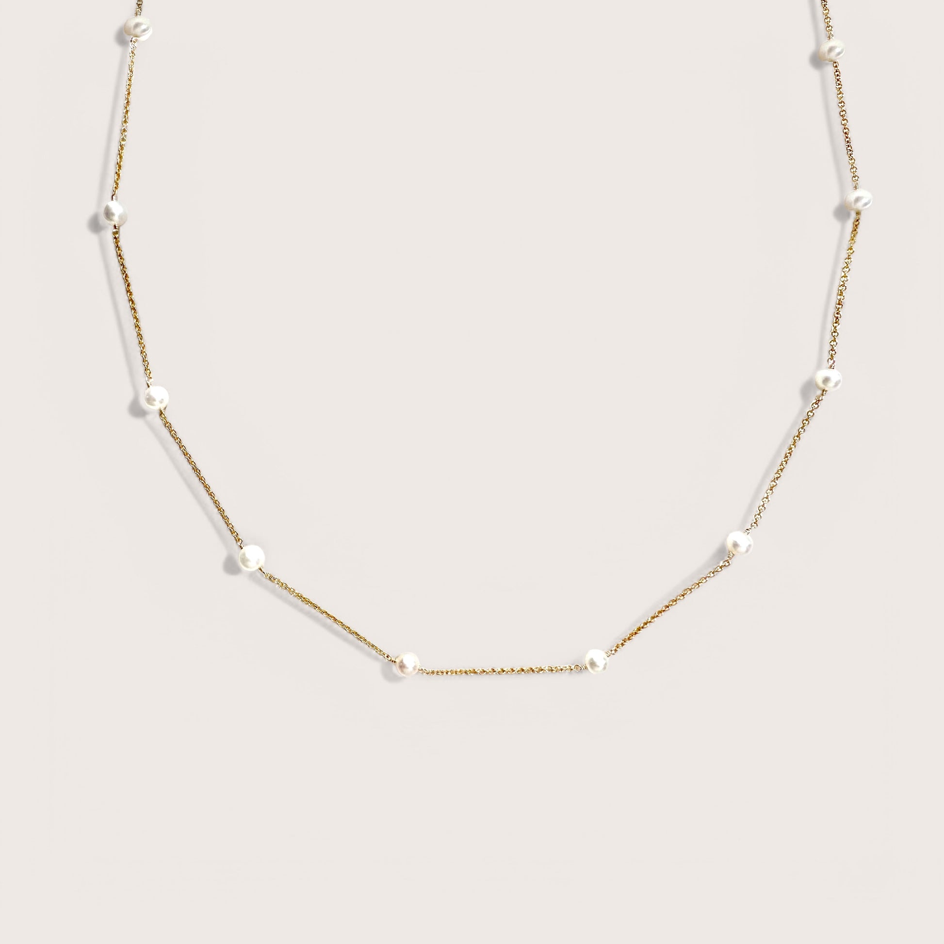 Close-up of ivory white pearls on gold filled station chain