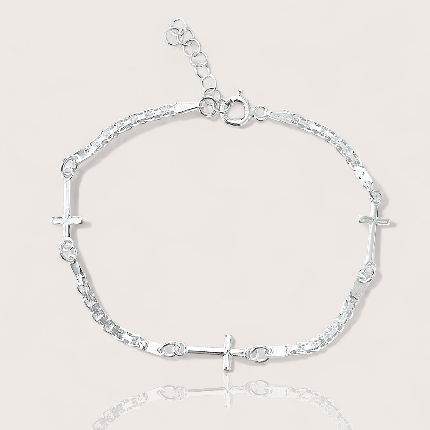 Adjustable Sterling silver linked crosses bracelet on plain background