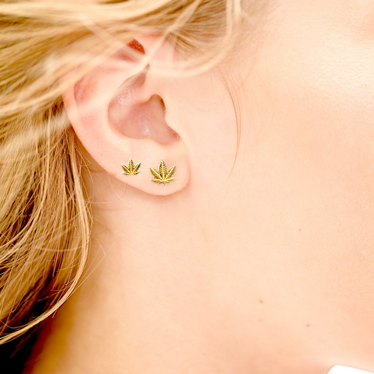 Side by Side front view of Both gold pot leaf earring sizes shown on a models ear