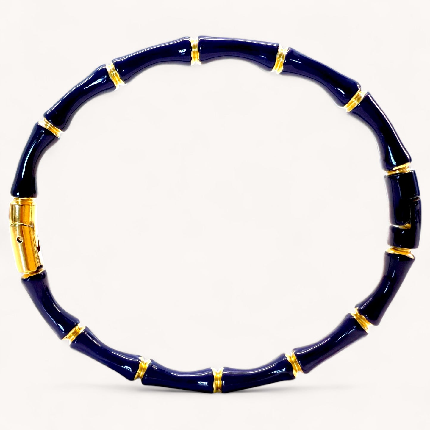 Navy blue bracelet with gold accents on a white background
