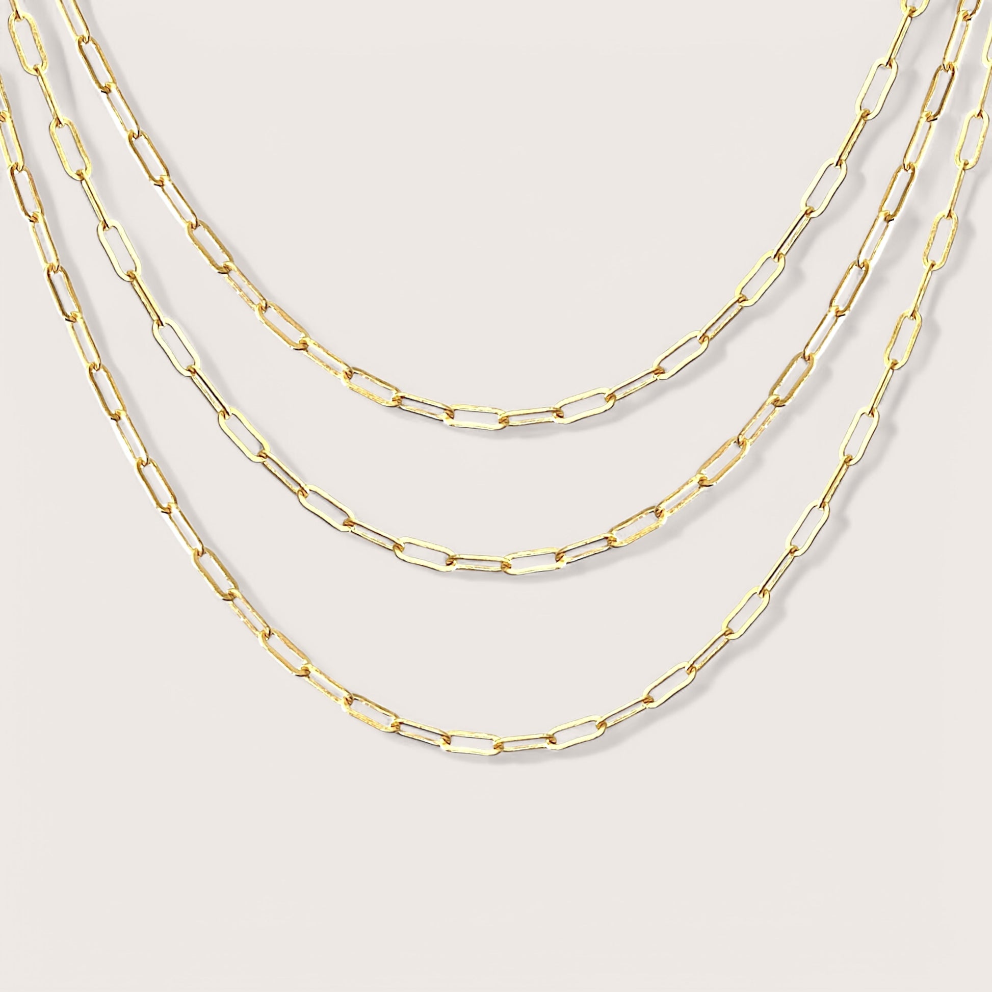 Elegant Small Link Paperclip Chains. Crafted from 14K yellow gold filled, these versatile chains are ideal for everyday wear and can be effortlessly layered. These on-trend necklaces boast a timeless design that adds a touch of elegance to any outfit. Whether you’re gifting them or simply want to enhance your own style, these chains are sure to impress.