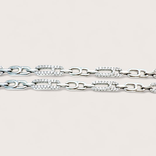 Silver chain bracelet with clear gemstones on a light gray background