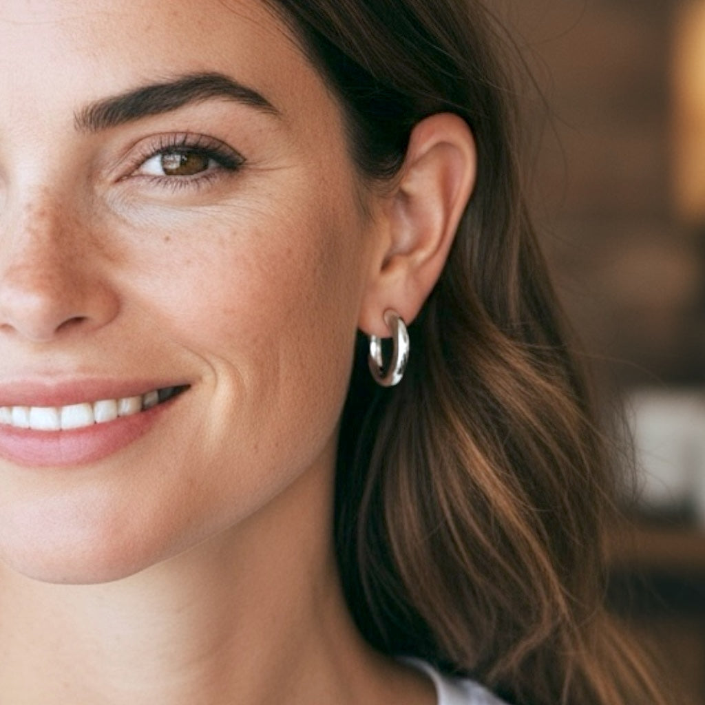 Close-up of a woman wearing a silver hoop earring with a blurred background