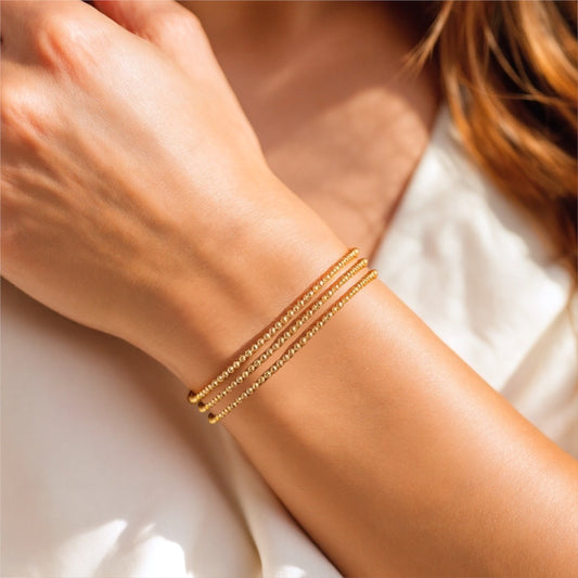 14k yellow gold filled 2mm bracelets stacked on a wrist
