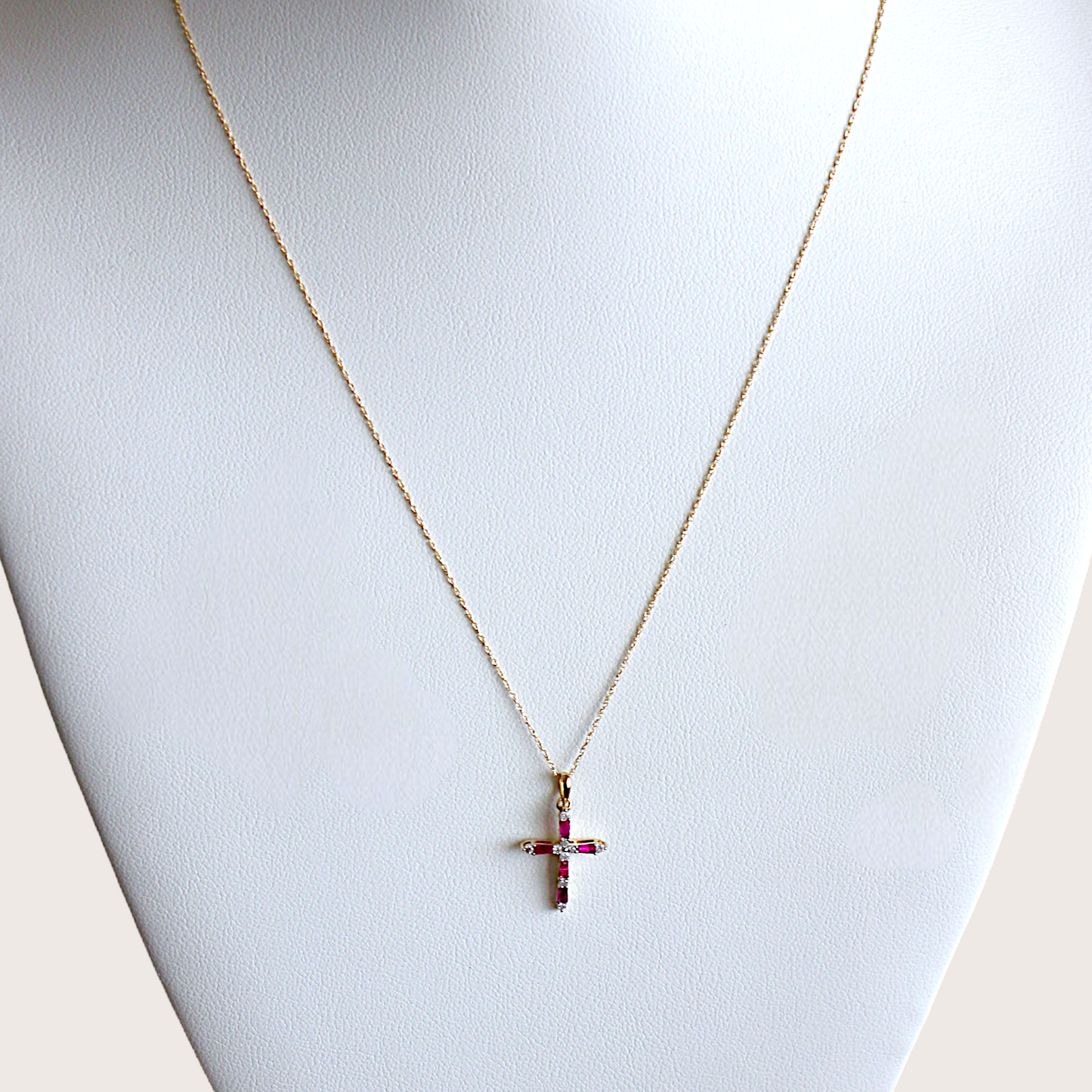 14K yellow gold ruby and diamond cross necklace on 18-inch chain on a mannequin bust.