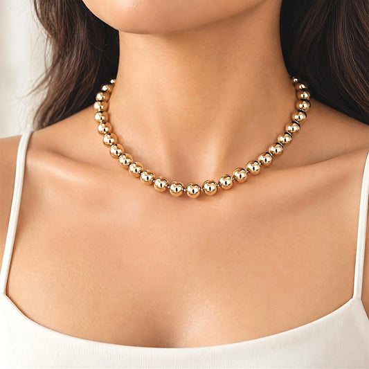 Close-up of a gold-filled bead necklace worn with a white camisole