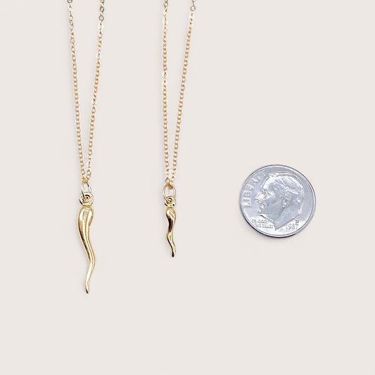Side-by-side scale comparison of the small and large gold filled Italian horn pendants next to a US dime coin