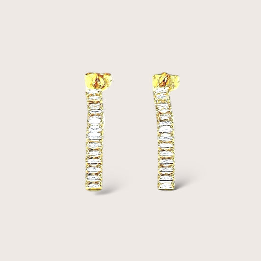 Infuse your ensemble with a touch of refined luxury by adorning yourself with our gold & clear crystal baguette dangle earrings. Fashioned with sparkling gemstones encased in 18K gold, these opulent earrings are ideal for any occasion and make a sophisticated and meaningful present for those with impeccable taste.
