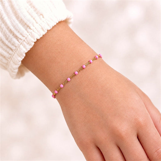 Light pink enamel and gold-filled bracelet worn on a child-sized wrist