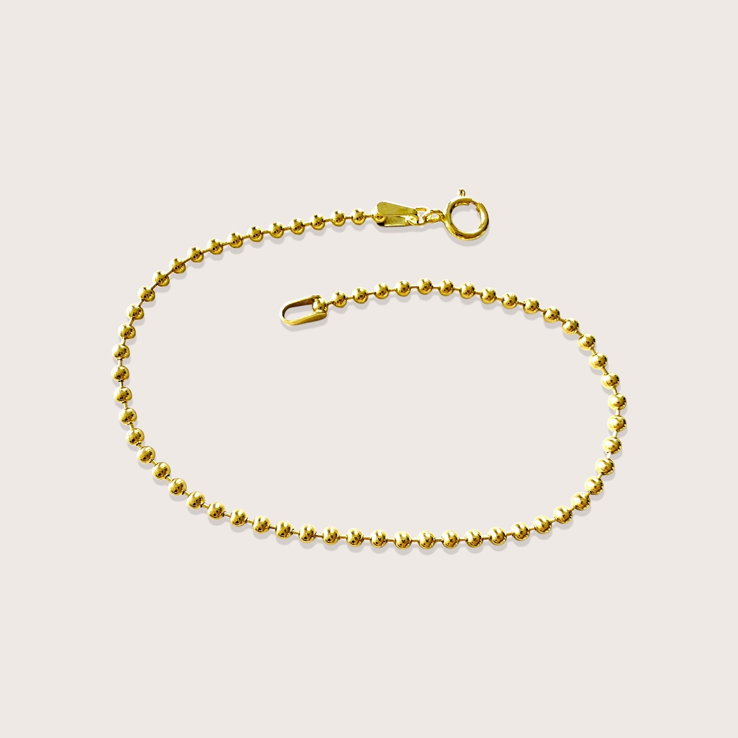Studio flat-lay view of the 14K gold-filled 2mm ball chain bracelet, showing the smooth round beads and spring-ring clasp, by Ashley Nicole Jewelry.