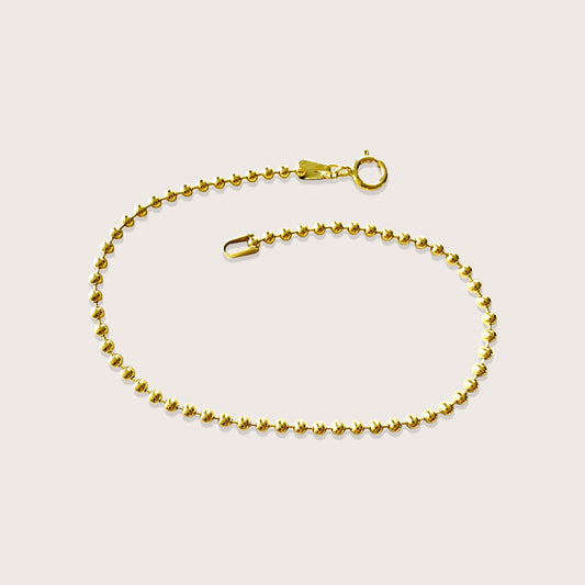 Studio flat-lay view of the 14K gold-filled 2mm ball chain bracelet, showing the smooth round beads and spring-ring clasp, by Ashley Nicole Jewelry.