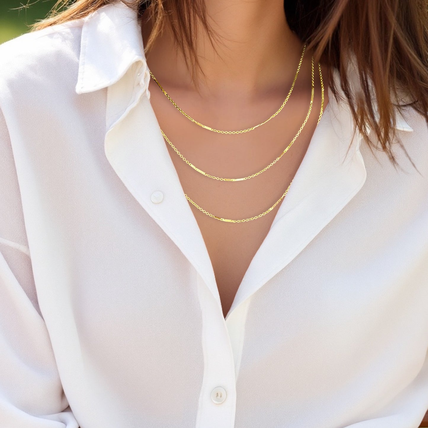 Model wearing layered chains for style inspiration, showing lengths in 16” - 20 of the 14K Yellow Gold Bar Station Chains