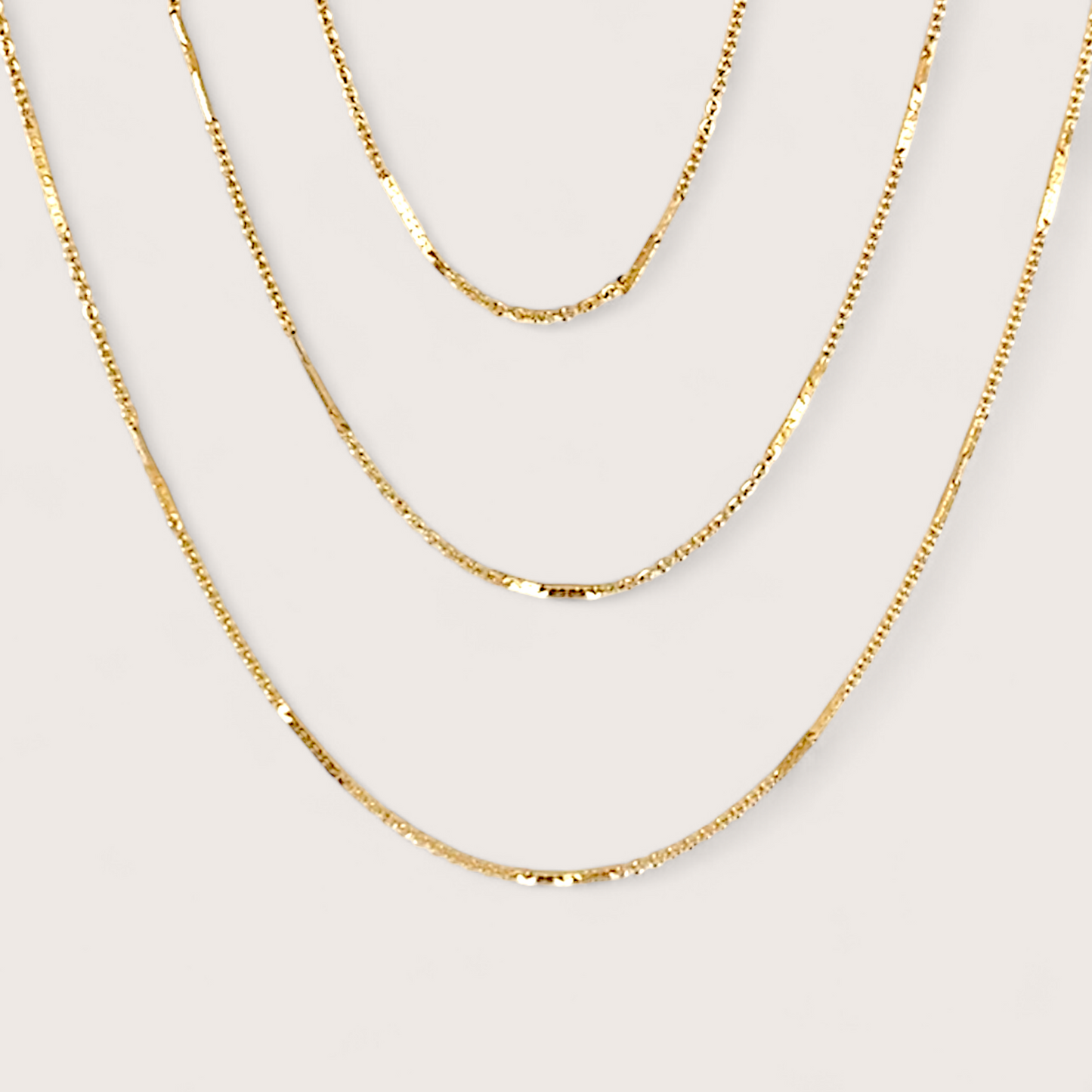 14K Gold Filled Bar Station Chain Necklace on plain background showing dainty dapped bar links layered with other gold chains.