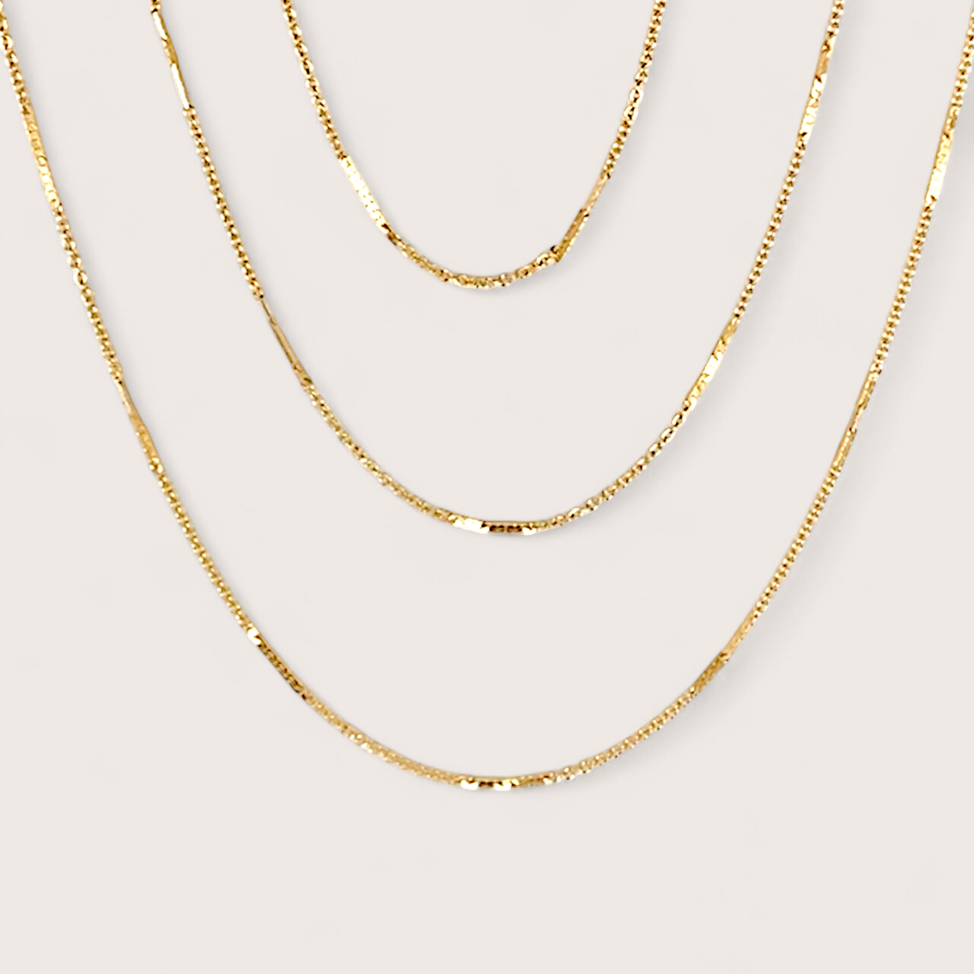 14K Gold Filled Bar Station Chain Necklace on plain background showing dainty dapped bar links layered with other gold chains.