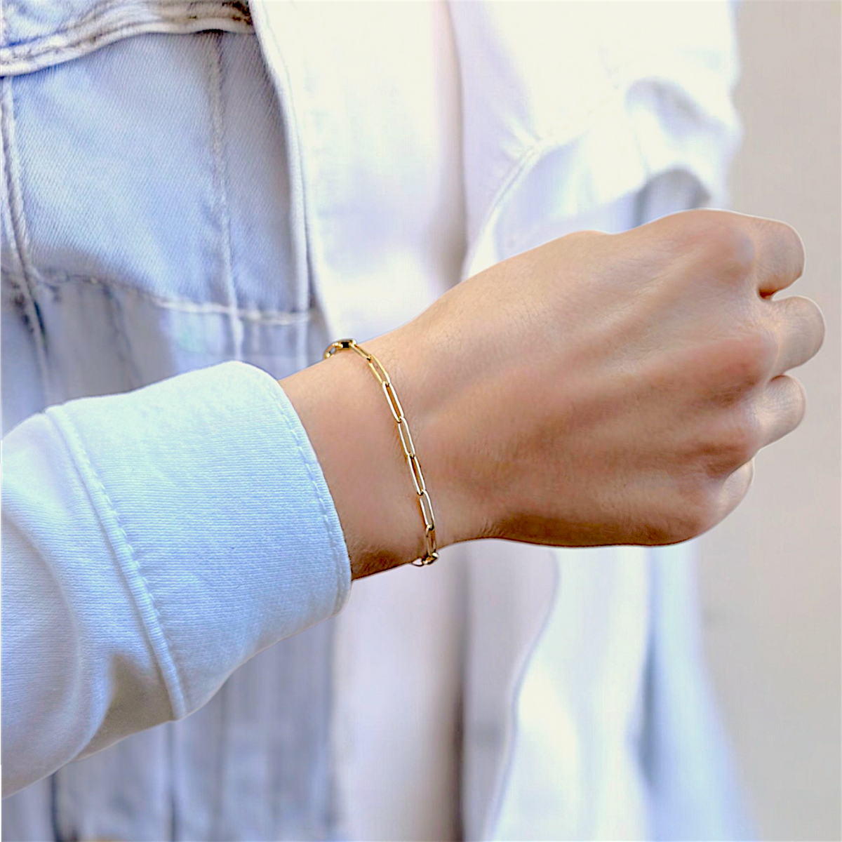 Gold paperclip link bracelet worn on a wrist
