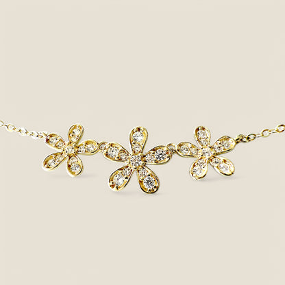 High-resolution product flat-lay of the 14k gold-filled Three Flower Bar Necklace by Ashley Nicole Jewelry centered on a white background
