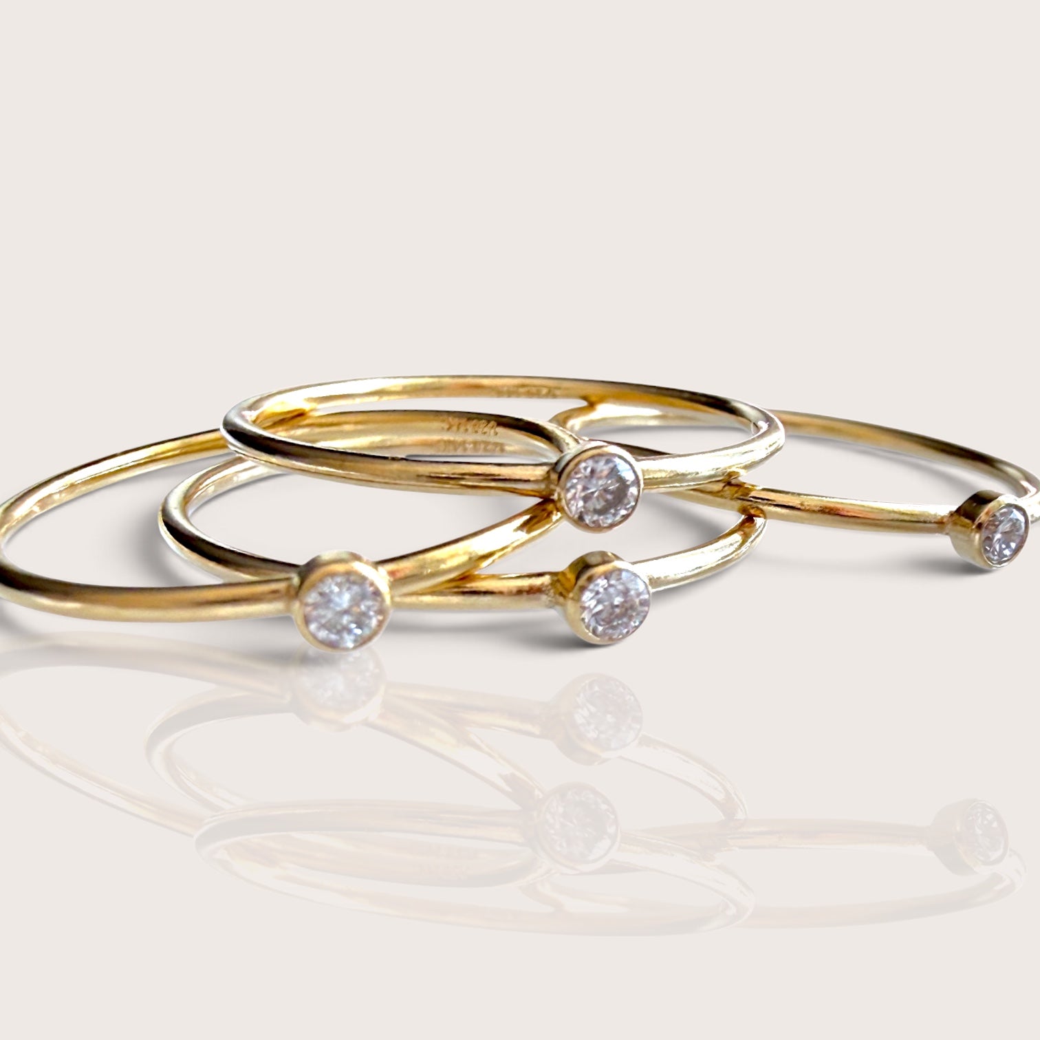 Set of four 14K gold filled rings stacked together featuring the 2.0mm lab diamond bezel solitaire band