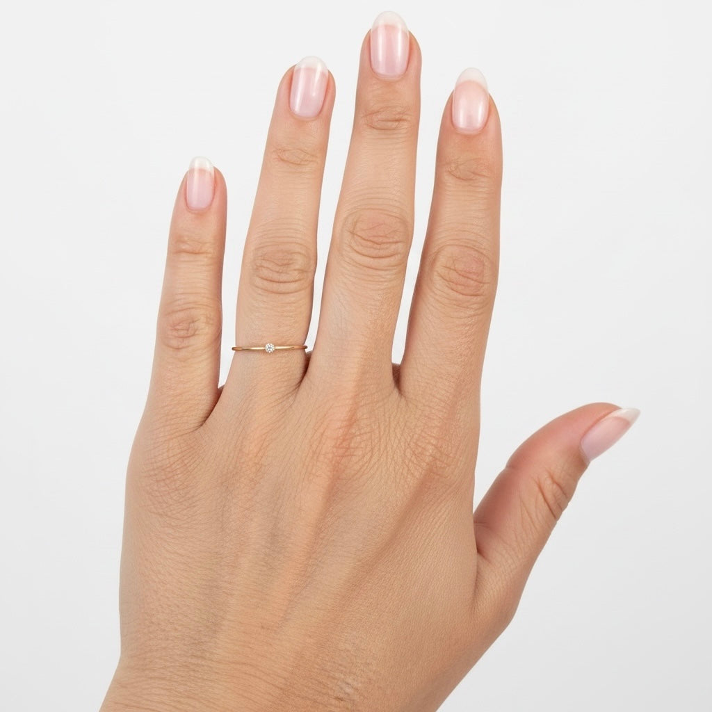 Model wearing single 14K gold filled 2.0mm lab grown diamond bezel solitaire ring on ring finger
