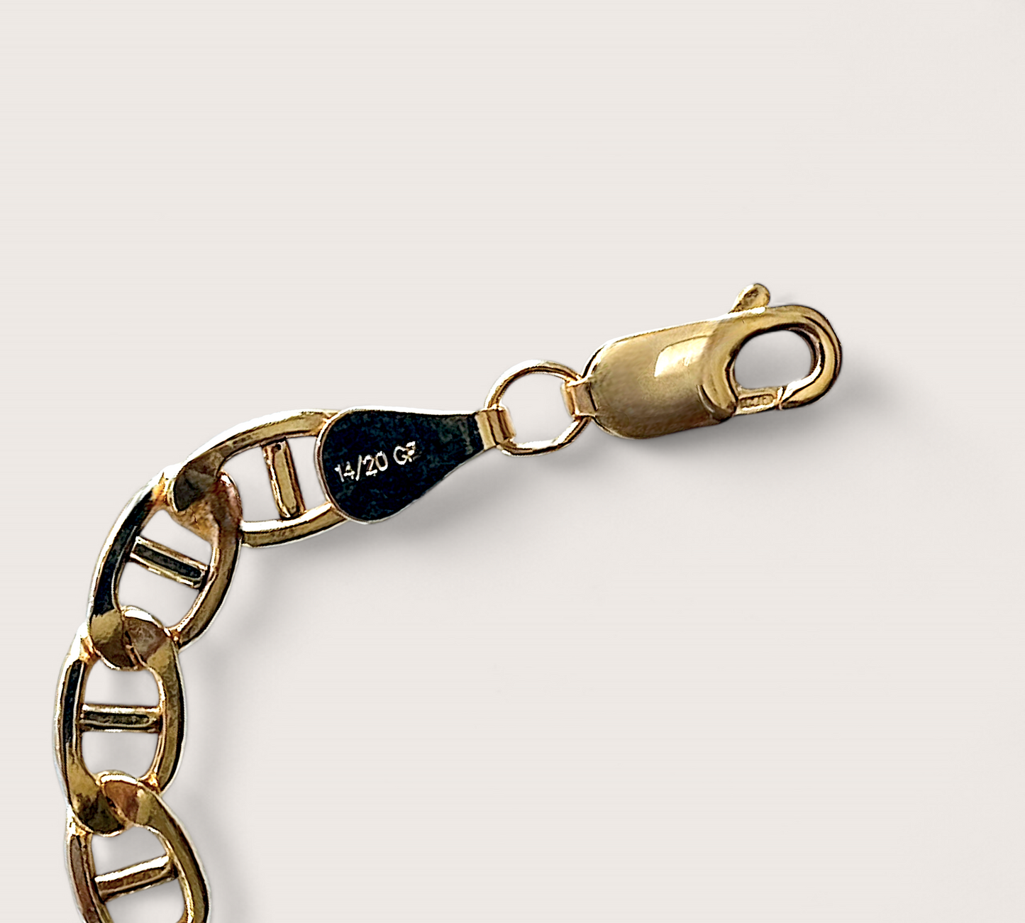 Detailed product shot of a 14k gold-filled flat mariner (anchor) link chain bracelet, featuring polished 5.0mm x 9.5mm links, displayed flat to show the extender chain and closure options. Available in 6.5" Fixed Length or 6.5" + 1" Extender, handmade by Ashley Nicole Jewelry.