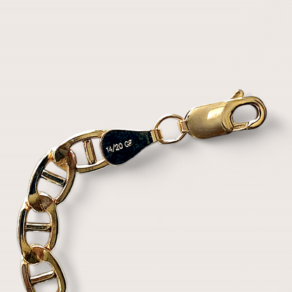 Detailed product shot of a 14k gold-filled flat mariner (anchor) link chain bracelet, featuring polished 5.0mm x 9.5mm links, displayed flat to show the extender chain and closure options. Available in 6.5" Fixed Length or 6.5" + 1" Extender, handmade by Ashley Nicole Jewelry.