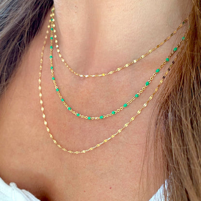 Gold-filled mirror Valentino necklaces layered with a green station necklace