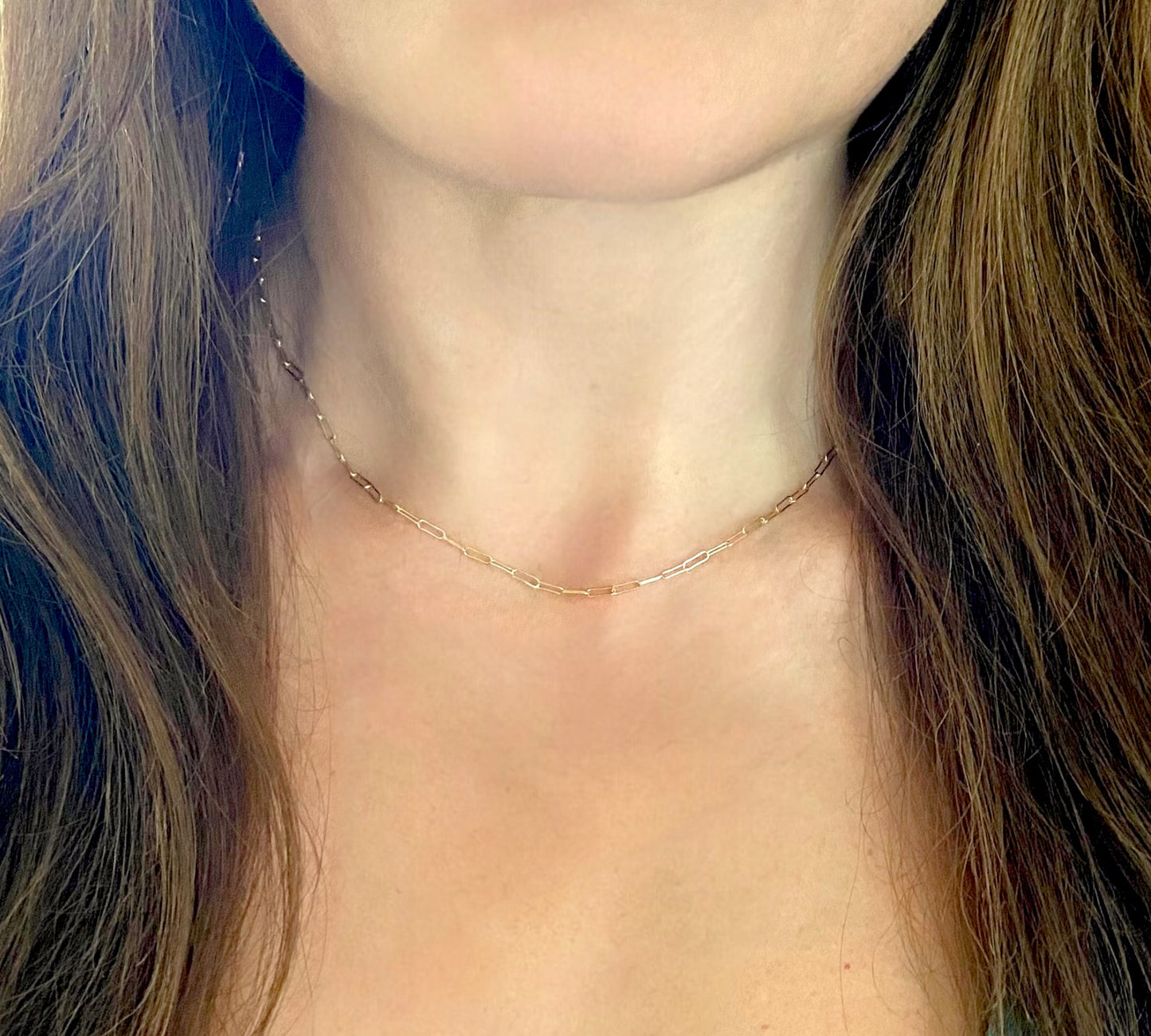 model wearing a dainty 14K gold-filled flat link paperclip chain necklace by Ashley Nicole Jewelry
