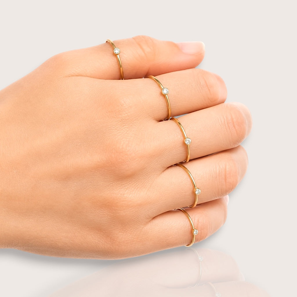 Full hand jewelry styling showing five 14K gold filled rings worn across thumb, index, middle, ring, and pinky fingers
