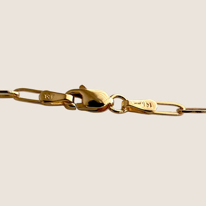 Close-up of the gold paperclip bracelets lobster clasp, connecting ring, and stamped end tabs