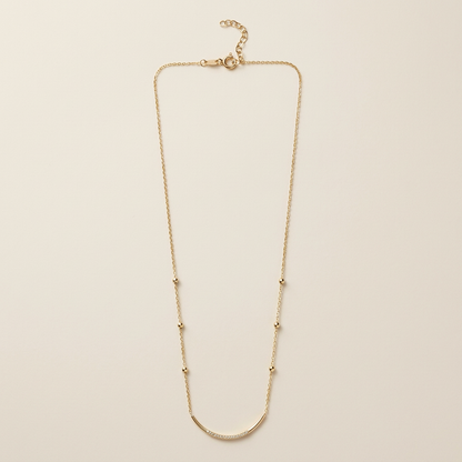 Full gold satellite necklace showing the curved CZ bar, six bead stations, spring-ring clasp, and extension chain
