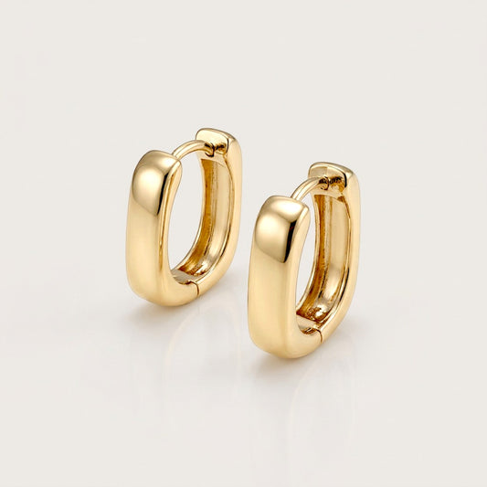 Pair of chunky gold rectangular huggie earrings with rounded corners, shown at an angle on a neutral background.