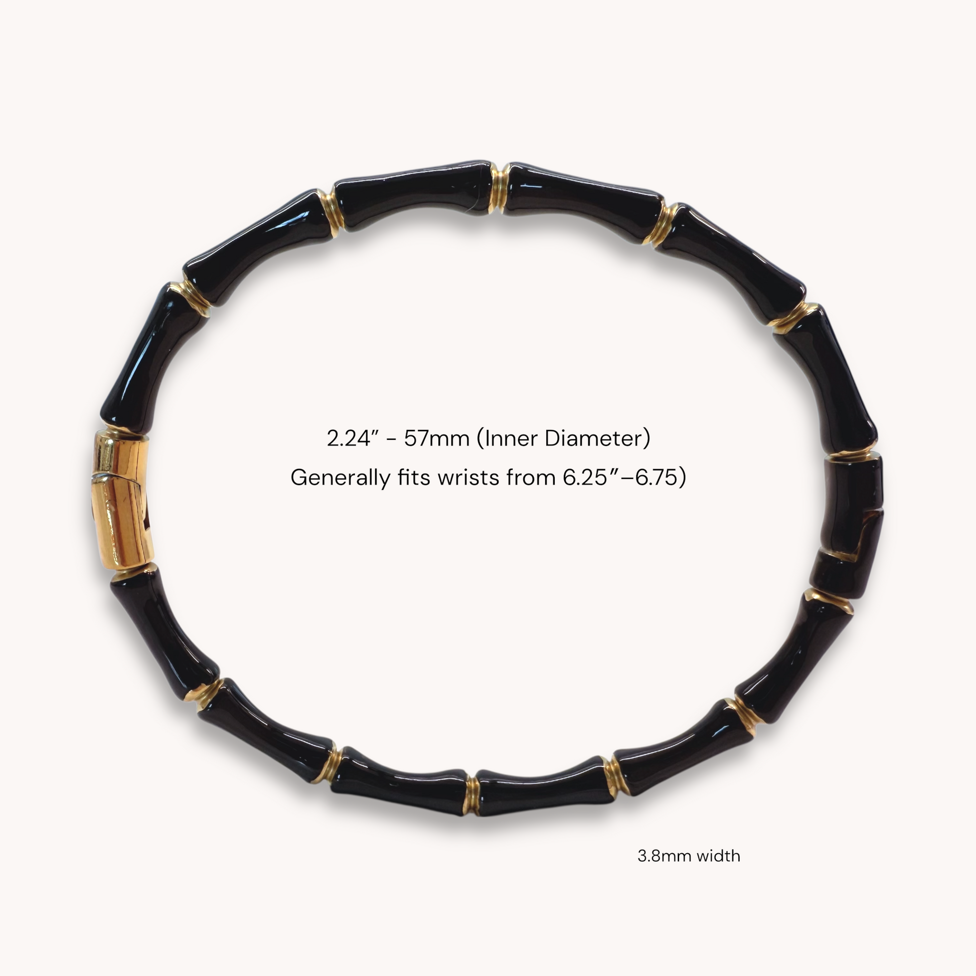 Close up image of an 18k gold plated stainless steel bamboo bangle bracelet with black enamel showing details of the geometric wood inspired nodes and a glossy color finish by Ashley Nicole Jewelry.