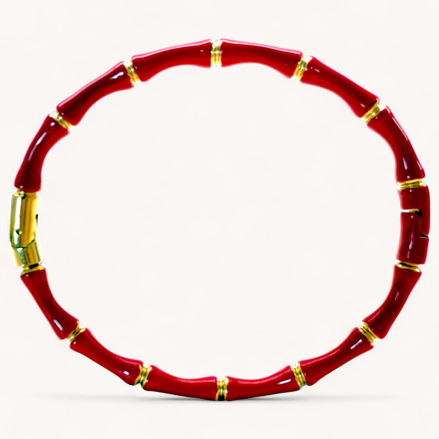 Close up image of 18k gold plated stainless steel bamboo bangle bracelets with high gloss Red color enamel finish showing details of the geometric wood inspired nodes by Ashley Nicole Jewelry.