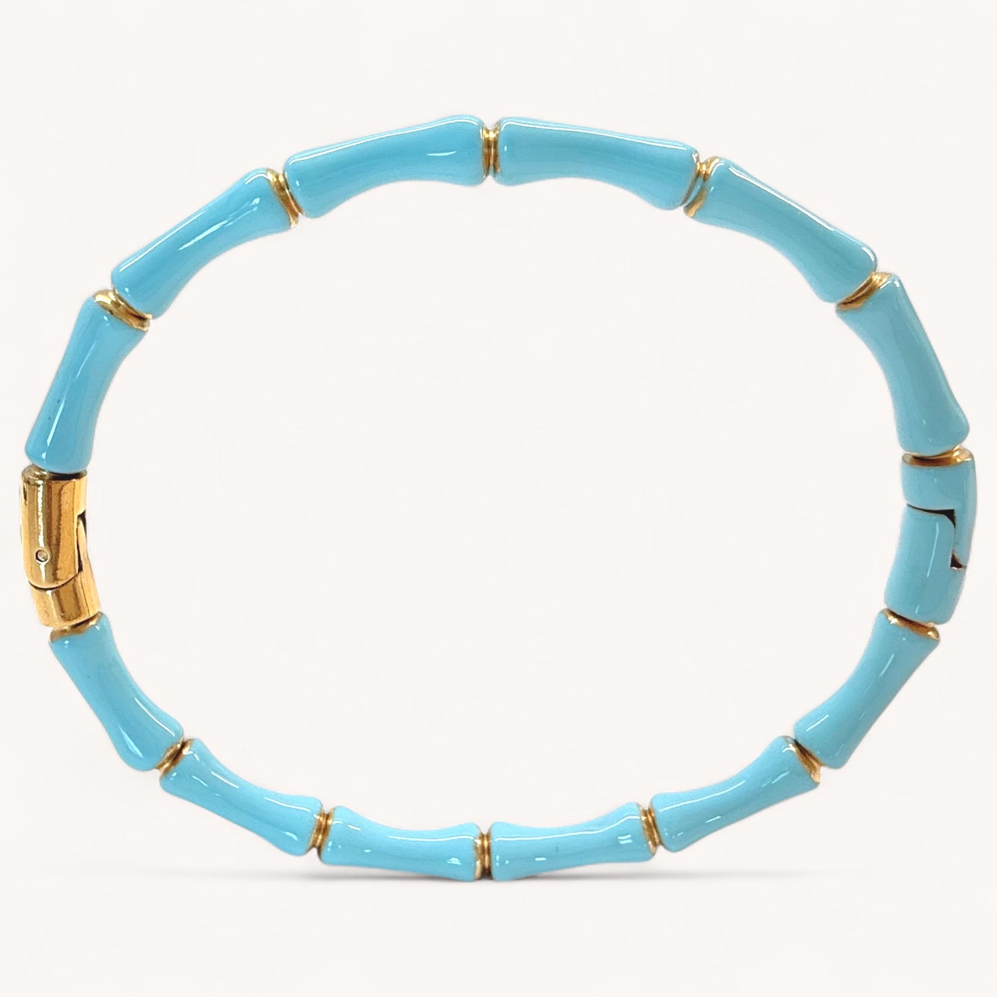 Close up image of 18k gold plated stainless steel bamboo bangle bracelets with high gloss Turquoise color enamel finish showing details of the geometric wood inspired nodes by Ashley Nicole Jewelry.