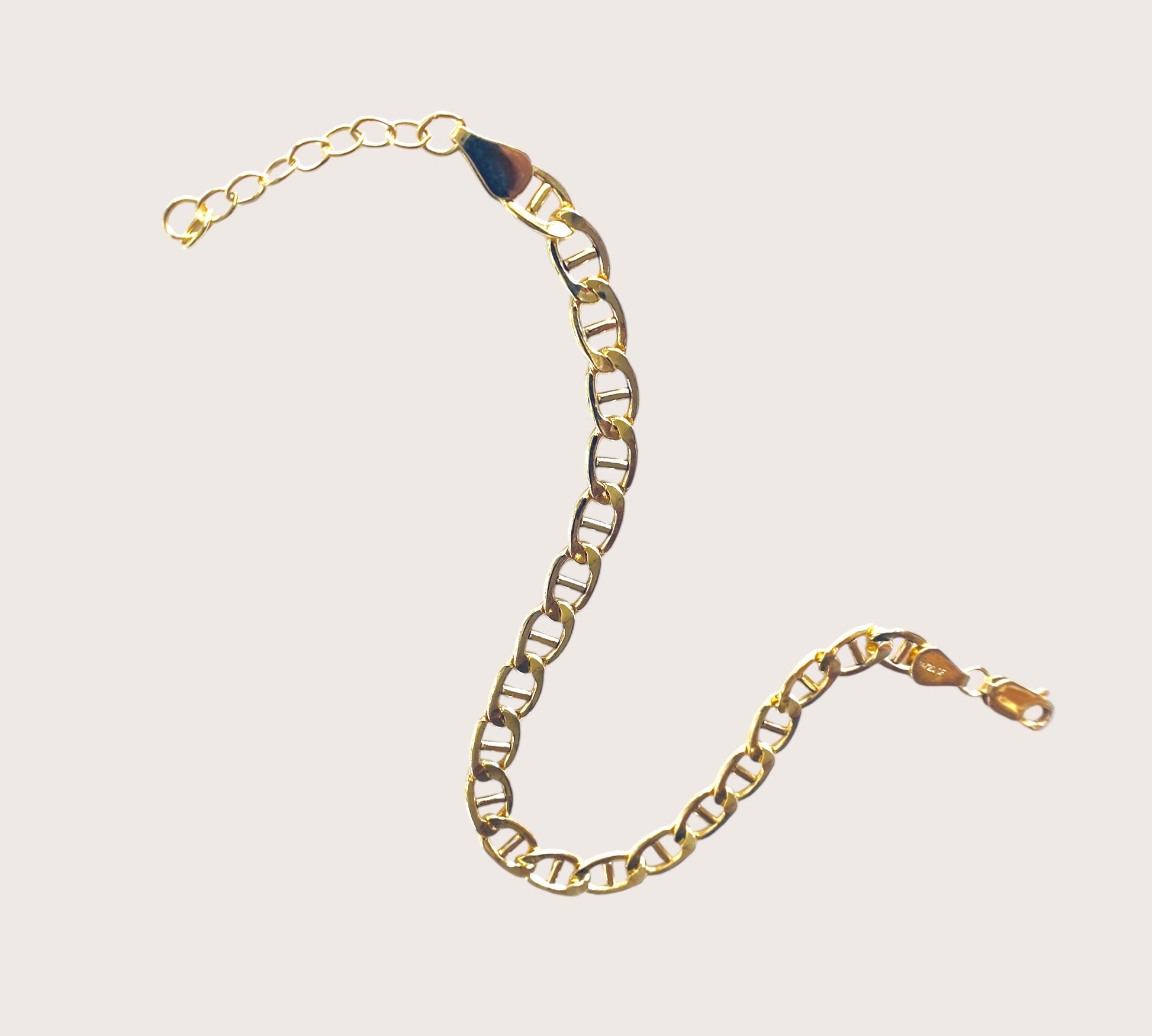 Detailed product shot of a 14k gold-filled flat mariner (anchor) link chain bracelet, featuring polished 5.0mm x 9.5mm links, displayed flat to show the extender chain and closure options. Available in 6.5" Fixed Length or 6.5" + 1" Extender, handmade by Ashley Nicole Jewelry.