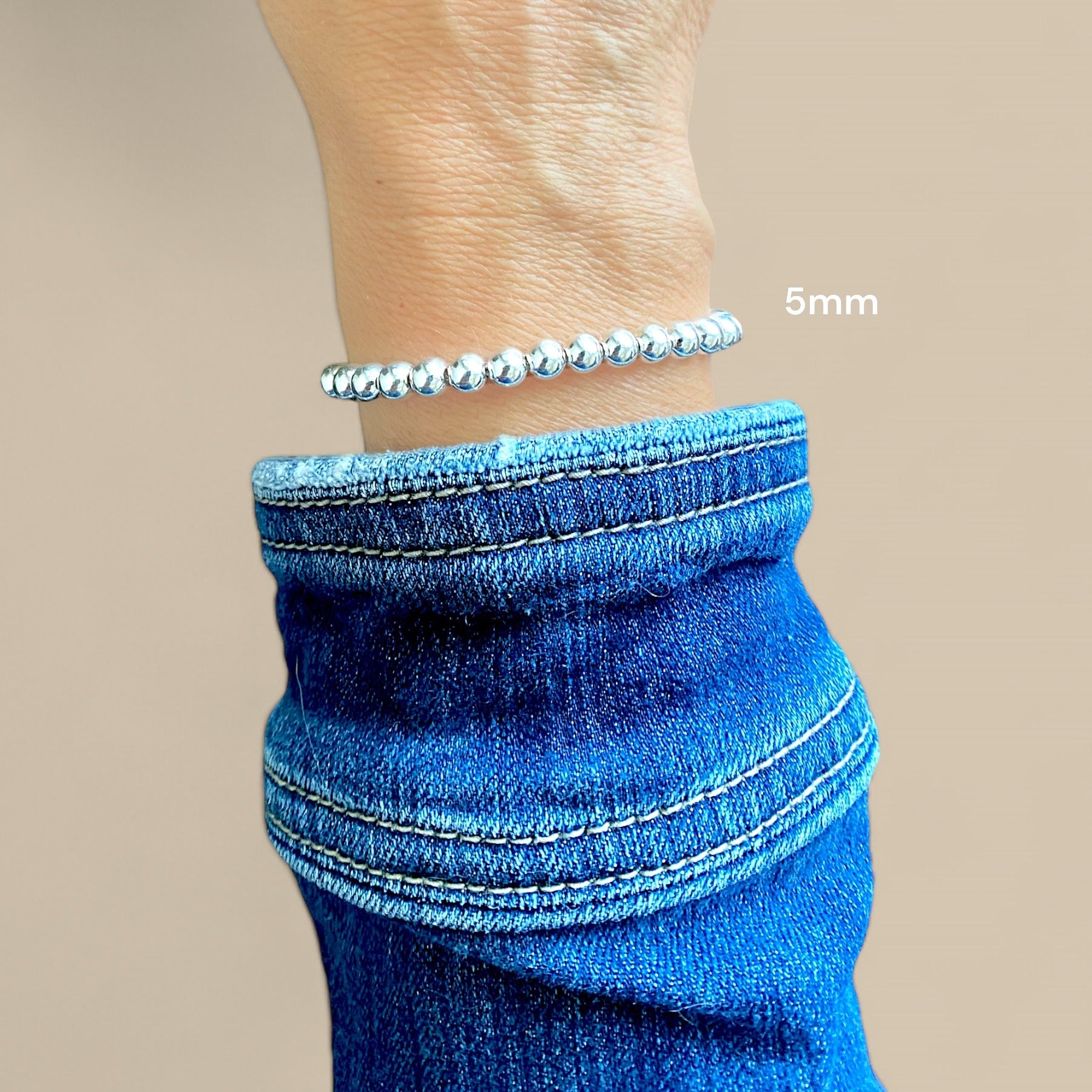 A 5mm sterlings silver beaded chain bracelet with a lobster claw closure.on a mocel