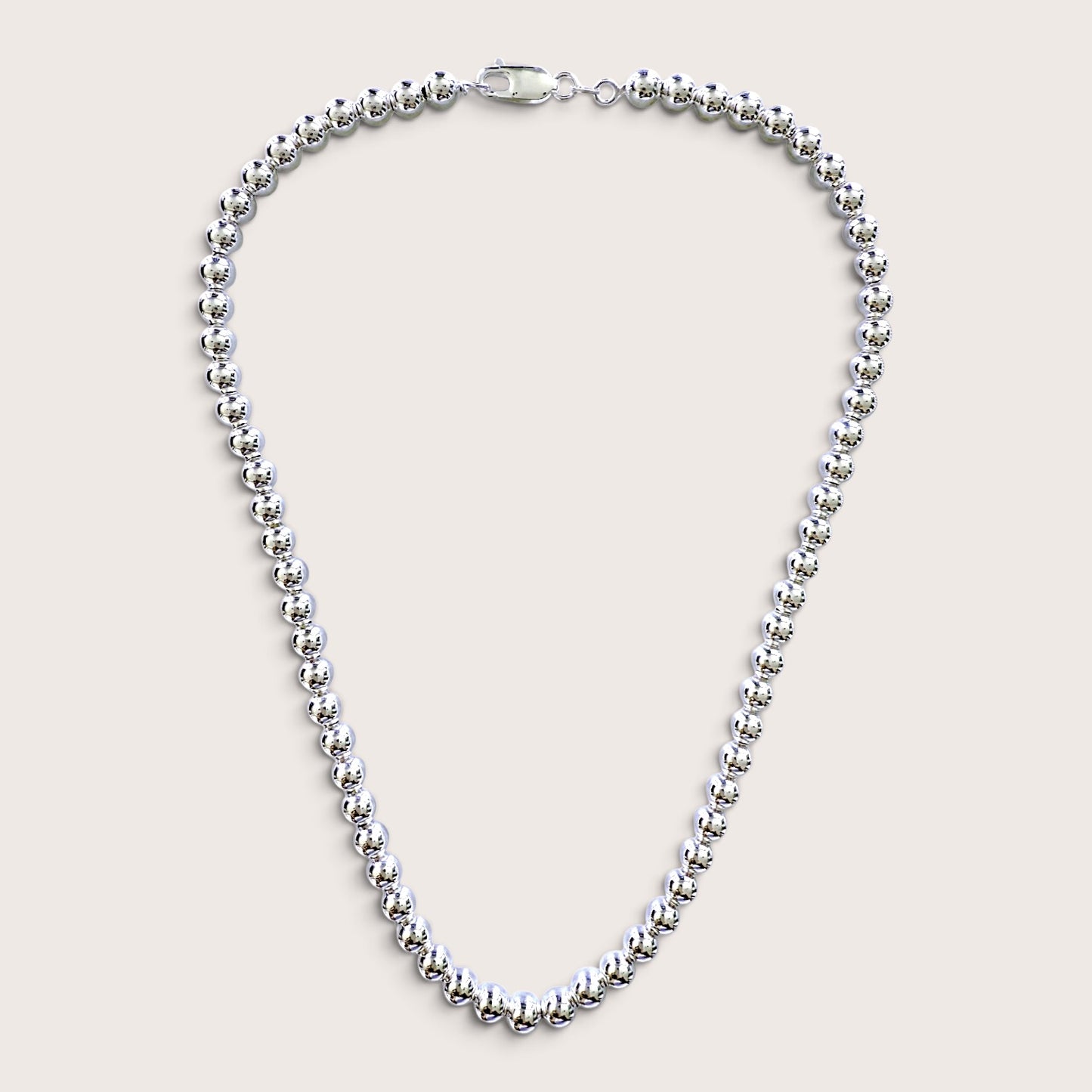 A Sterling Silver 6mm Beaded Necklace, adjustable lengths with a mirror polished finish and a lobster clasp, displayed on a light beige background.