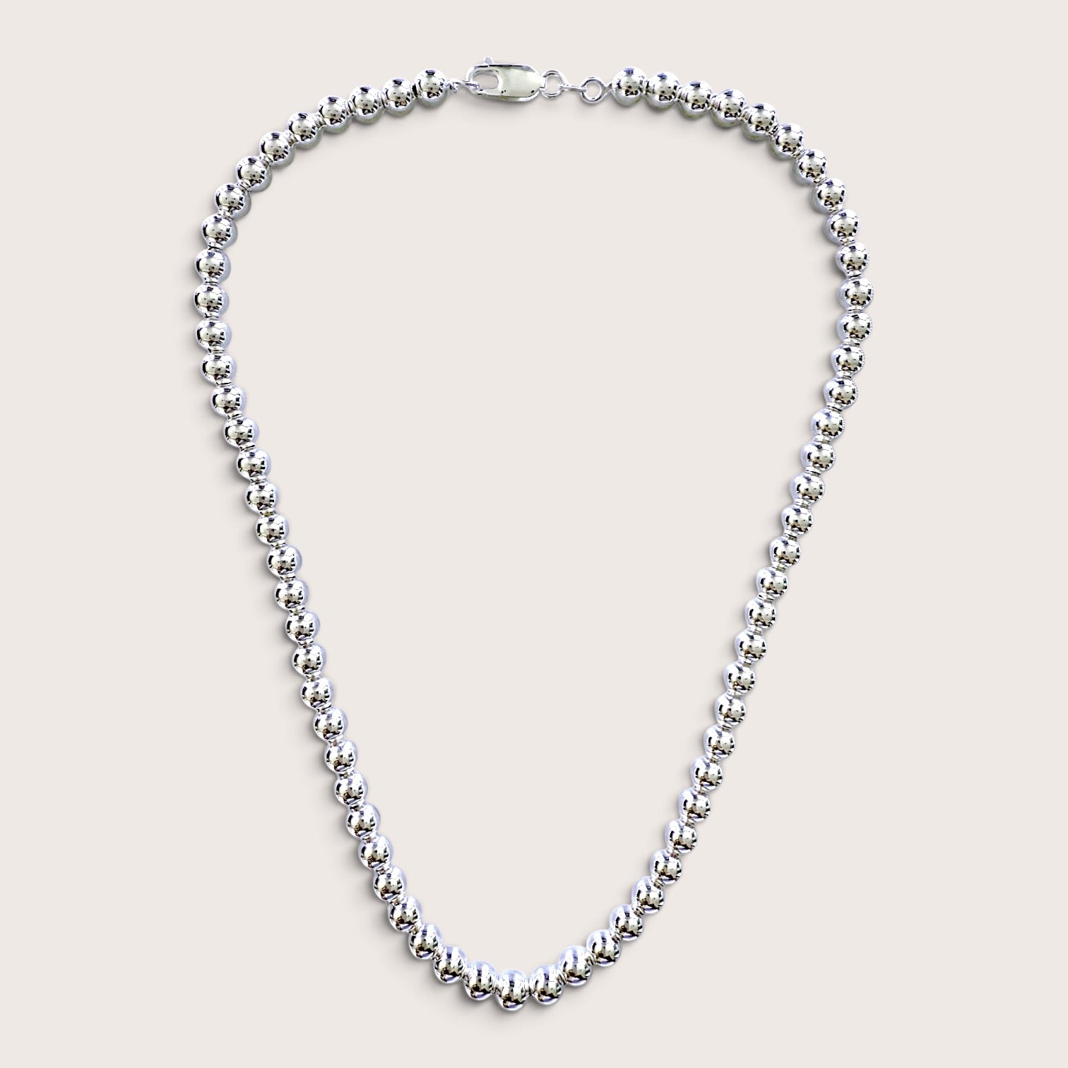 A Sterling Silver 6mm Beaded Necklace, adjustable lengths with a mirror polished finish and a lobster clasp, displayed on a light beige background.
