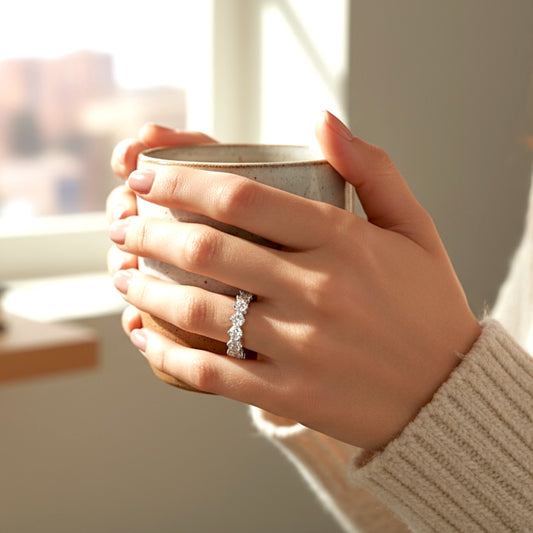 Model wearing a silver cz eternity ring while holding a mug